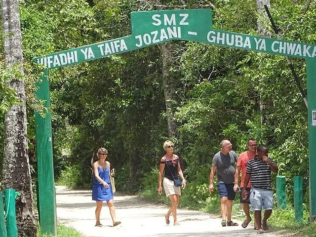 Tourists walking under the entrance sign to Jozani Chwaka Bay National Park