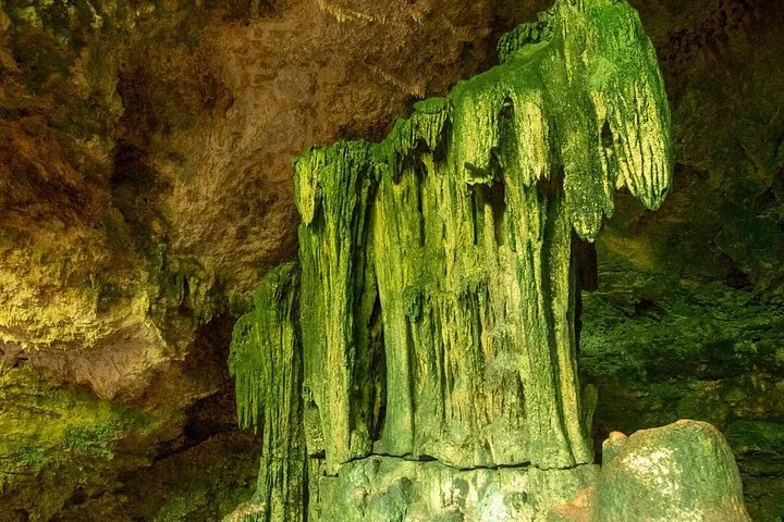 Große grüne Stalaktitenformation in einer Felshöhle.